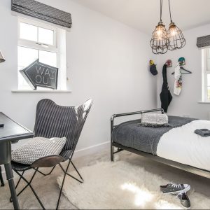 Modern teenager's bedroom with grey, white and black accents and decorations, fluffy white rug