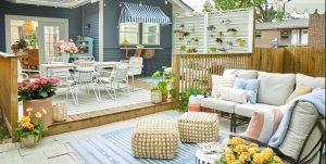 Outdoor garden space with dining table, sofas, cushions, throws, footstools, patio and rugs